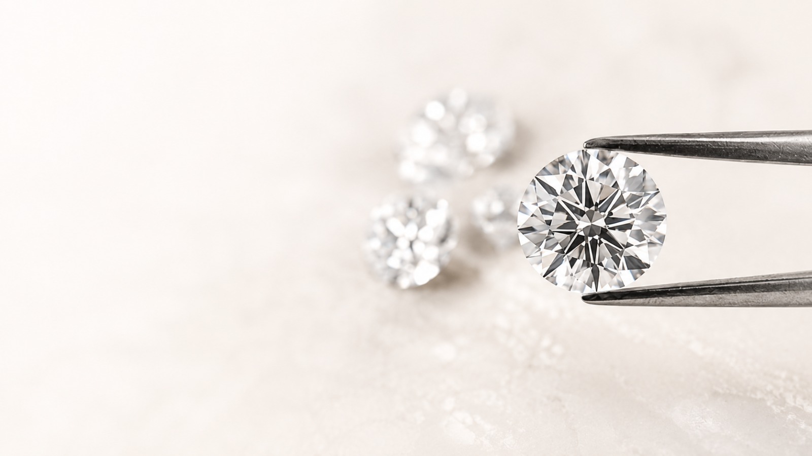 A round brilliant diamond held in tweezers
