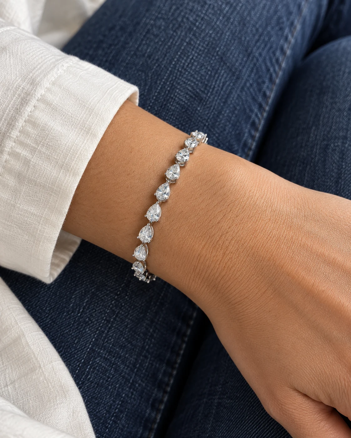 Illustrative close-up of bracelet worn with an ivory shirt and denim